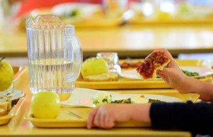 Une petite fille qui mange à la cantine
