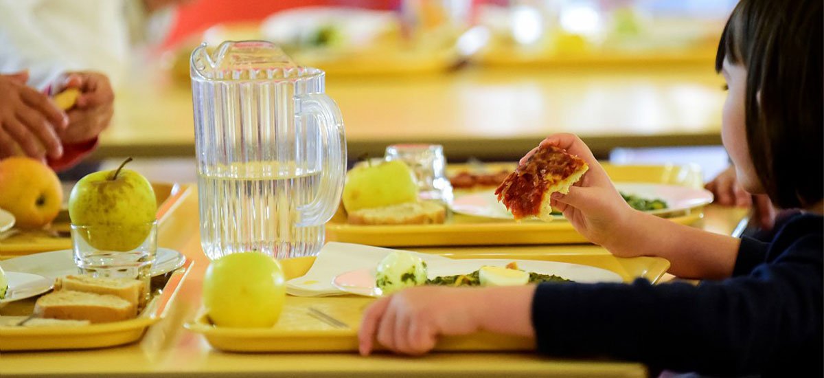 Une petite fille qui mange à la cantine